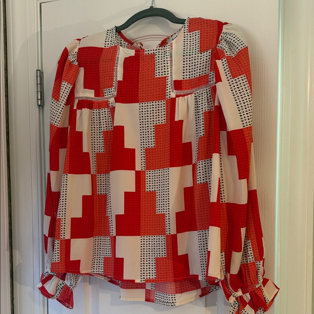 Red, coral, black & white blouse. Button closure in back, ruffles on wrists.